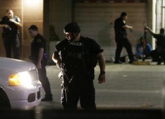 Dallas police detain a driver after several police officers were shot in downtown Dallas, Thursday, July 7, 2016. Snipers apparently shot police officers during protests and some of the officers are dead, the city's police chief said in a statement. (AP Photo/LM Otero)